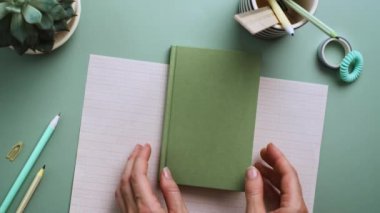 Eller mavi arka planda temiz boş sayfalar olan defterleri açar. Ofis masası, minimalizm. Dikey video çerçeve 9x16