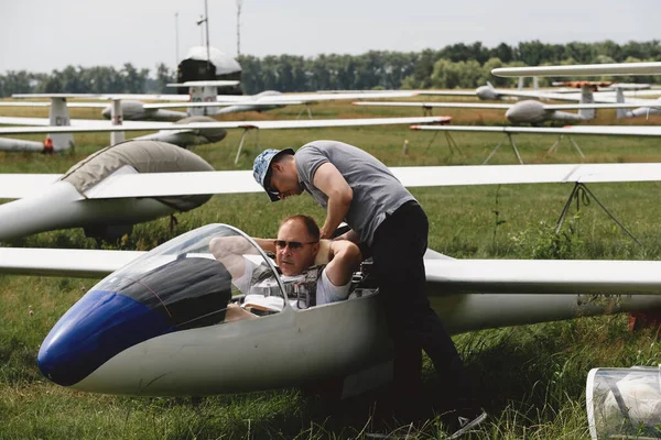 急降下クラブ グライダー飛行機のフライトの準備をしてください 小型航空スポーツ ヴィンテージ飛行機の機内機器パネルをチェックする2人の男 — ストック写真