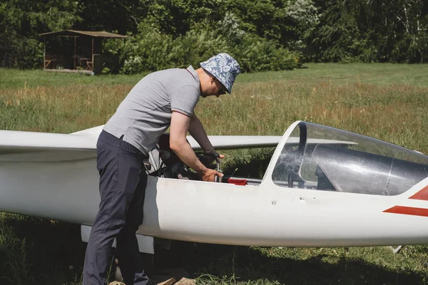 グライダーパイロットは モーターのない固定翼機での飛行の準備をしています 小さな航空極端なスポーツレジャー活動 上昇クラブの飛行機の近くの男 — ストック写真