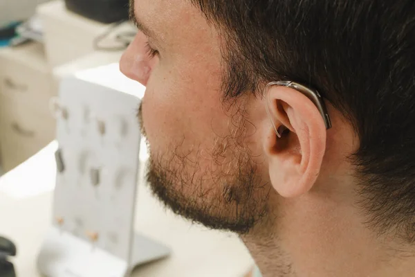 Człowiek Próbuje Nowoczesnych Aparatów Słuchowych Zbliżenie Ucha Pacjenta Klinika Rehabilitacji — Zdjęcie stockowe