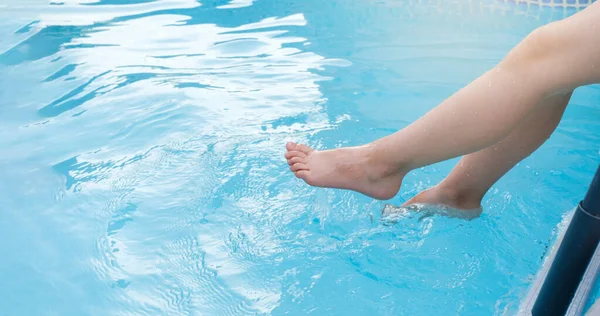 stock image Kids legs splashing in water near swimming pool outdoors. Summertime activities for children. Copy space, closeup. Clear water