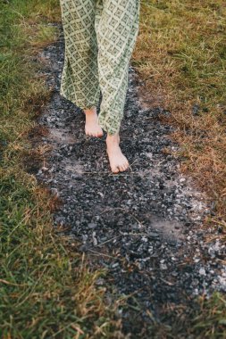 Kömür yürüyüşü ya da ateş yürüyüşü. Yanmış odun ve sıcak közlerin üzerinde çıplak ayaklı biri. Eğitim irade ve iyileşmek için güç. kabul ve inanç