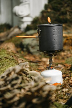 Turist mutfağında, yosun üzerinde gaz ocağında yemek pişirmek. Seyahat konsepti hayalleri.