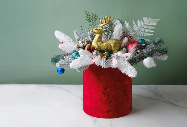 スプルース テーブルの装飾のためのフェルンが付いている赤い箱のクリスマスの構成 ボブスと雪の束 花屋によって組み立てられた美しい包装のトナカイ テーブルの上の花の装飾 — ストック写真