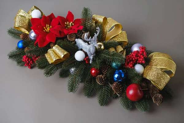 装饰圣诞构图从冷杉树枝为餐桌或壁炉 驯鹿玩具和带有泡泡和浆果的金色缎带 — 图库照片