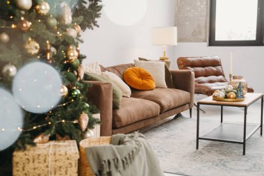 Livingroom 'un Noel arkaplanı. Mücevherler ve Noel küçük oyuncak ağaçları altın ve yeşil renkli kanepe tepsilerinde. Yeni yıl odasının içi bulanık, yumuşak odaklı.