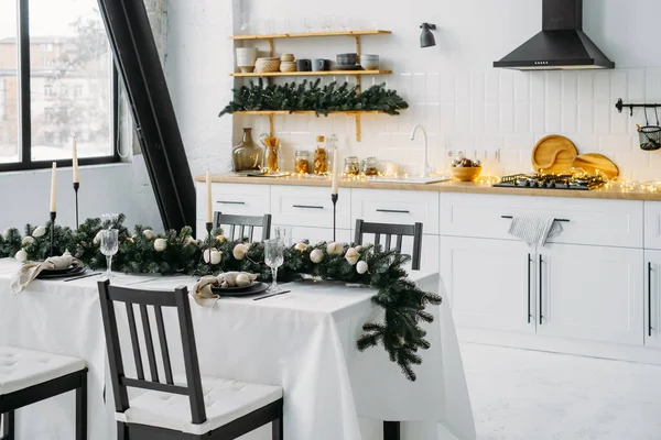 ガーランドとキッチンのクリスマスの装飾 ホームインテリアのお祝い 割り当てられたライト上のクリスマス テーブルの設定 スカンジナビア様式 — ストック写真