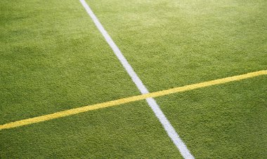 Açık alanda çizgileri olan yeşil spor sahaları. Günbatımında tenis kortu, kopyalama alanı. Güneşli bir spor alanı. Arkaplan