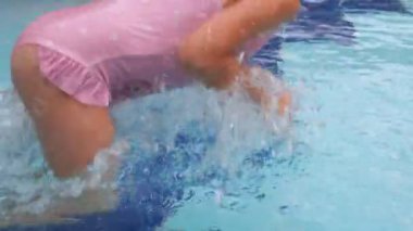 Yüzme havuzuna dalan çocuk. Bebek gözlüklerle suya atlıyor ve yüzmeyi öğreniyor. Suda eğlenen kız, Aquapark 'ta su sıçratan. 