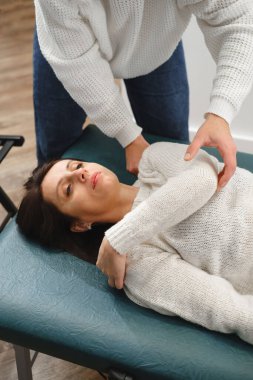 Kadın Osteopat Terapist, teşhis ve tedavi için hastanın omzunu muayene ediyor. Elle Terapi yoluyla Profesyonel Bakım ve ağrı kesici