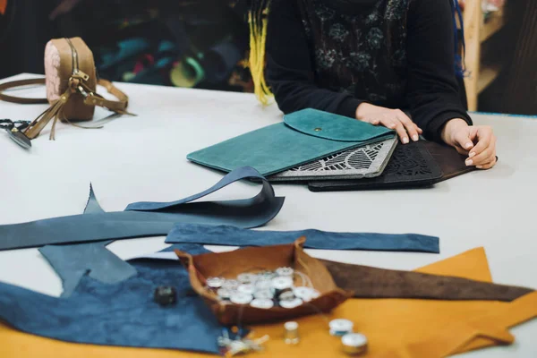 Eco leather laptop cases production. Close up of female tailor working with eco leather textile at workshop. Upcycling design concept. Copy space