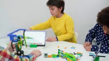 Kodlama sınıfı, liseli kız robot kol mekanizması yapıyor. Bilim yapan çok ırklı çocuklar, tabletli teknolojik görevler. Modern eğitim Afrikalı Amerikalı kız ders üzerinde deney yaparken eğleniyor.