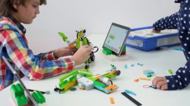 Çocuklar okulda kodlama, fen ve teknoloji öğreniyor. Afrika kökenli Amerikalı ve Kafkasyalı çocuklar STEM dersinde dizüstü bilgisayarlarıyla geziyorlar. Modern yenilikçi eğitimde çeşitlilik