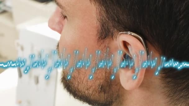 男人尝试现代紧凑型助听器 病人耳朵的闭锁 中老年聋人听力康复诊所选择数字设备 — 图库视频影像