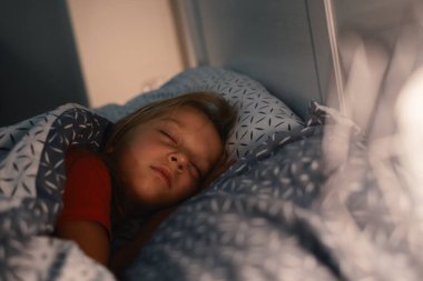 Geceleri uyuyan çocuk. Çocuklar için rahat bir yatak. Küçük kız mışıl mışıl uyuyor, uykuya dalıyor, sağlıklı alışkanlıklar ve rahat bir yatak. 