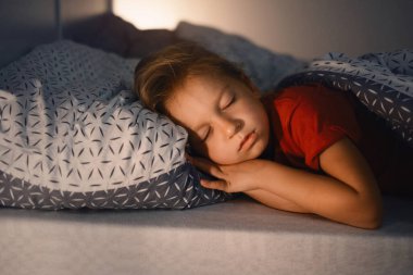 Geceleri uyuyan çocuk. Çocuklar için rahat bir yatak. Küçük kız mışıl mışıl uyuyor, uykuya dalıyor, sağlıklı alışkanlıklar ve rahat bir yatak. 