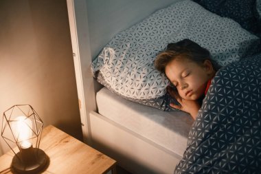 Geceleri uyuyan çocuk. Çocuklar için rahat bir yatak. Küçük kız mışıl mışıl uyuyor, uykuya dalıyor, sağlıklı alışkanlıklar ve rahat bir yatak. 