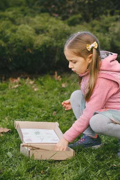 stock image Scavenger hunt for kid in the park. Girl learning about environment. Natural education activity for World Earth day. Exploring in spring.