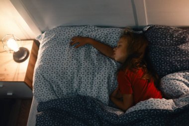 Geceleri uyuyan çocuk. Çocuklar için rahat bir yatak. Küçük kız mışıl mışıl uyuyor, uykuya dalıyor, sağlıklı alışkanlıklar ve rahat bir yatak. 