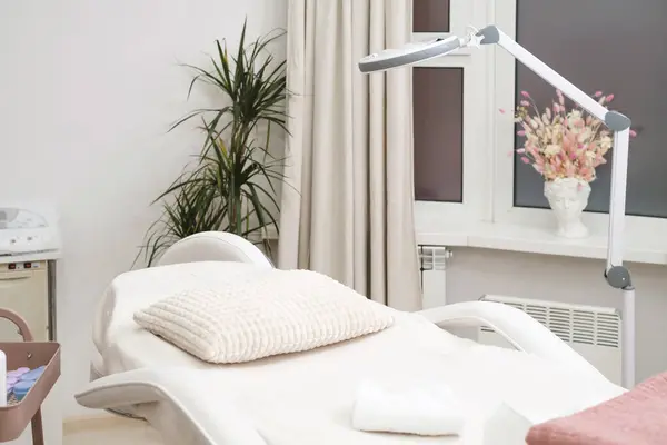 Güzellik kliniğindeki kozmetik işlemleri için modern boş dermatolog kozmetik masaj masası. Boş estetik tıp salonu