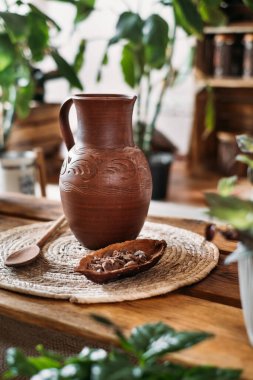 Tören için sıcak organik kakaolu sürahi, yakın çekim. Yeşil vejetaryen kafedeki çiğ kakao çekirdeğinden sağlıklı bir içecek. Mekanı kopyala, yeşil kırsal bölgede ahenk için ayin yap.