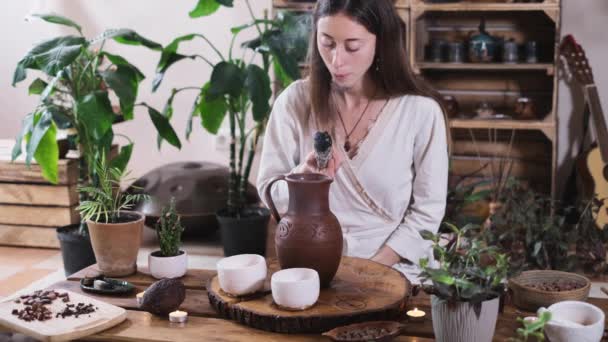 緑の植物とろうそくの大気圏でのカカオセレモニー カカオ豆から健康的な飲み物を作る女性 — ストック動画