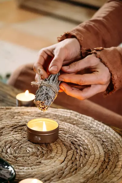 Masada mumlar ve yeşil bitkilerle ayin yapılmadan önce kadın elleri beyaz adaçayı yakıyordu. Leke dumanı acı ve stresi tedavi eder, temiz negatif enerji ve meditasyon.