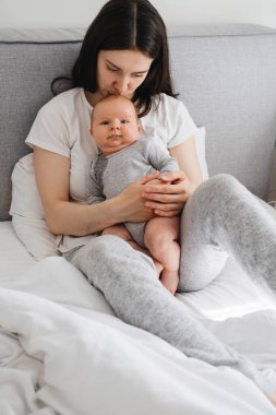 Anneni evde emzir. Bebek annesinin ellerinde oturuyor, bebeğe sarılıyor ve tatlı bir bebekle konuşuyor.