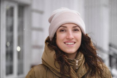 Açık havada kar taneleri yakalayan mutlu orta yaşlı kadın. Huzurlu, duygusal bir insan kışın şehir merkezinde yürüyor. Yavaş yavaş yaşıyor, samimi, otantik bir hayat sürüyor.