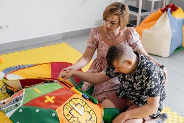 Engelli çocuklar oyuncaklar, toplar, küçük nesneler, sakinleştirici oyun oynayan serebral felçli çocuklar, iyi motor becerileri eğitiyorlar. Terapistli rehabilitasyon merkezi, anne.