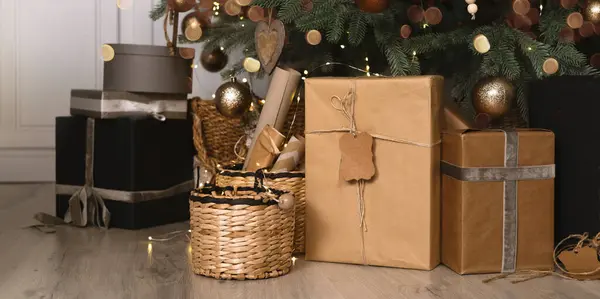 Odadaki köknar ağacının altında Noel hediyeleri. Çevre dostu hediyeler odada kutlama için bekliyor. Pankart