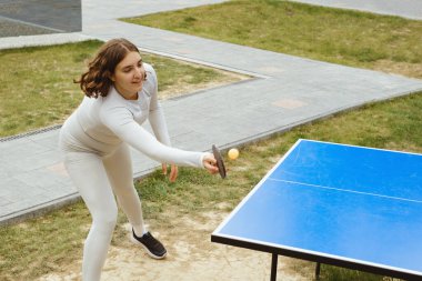 Kadınlar modern açık hava tatil beldesinde aktif masa tenisi oynamaktan hoşlanırlar. Yaz aylarında seyahat ederken arkadaşlar için sağlıklı boş zaman aktiviteleri.