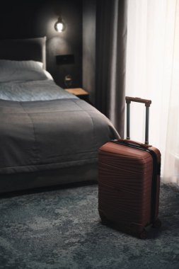 Karanlık modern otel odasında bavul.