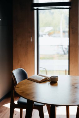 Siyah dolabı olan şık bir ev mutfağı, ahşap bir aksan duvarı ve rahat bir çatı katı yemek odası. Konfor, yemek ve okumak, kitap, bardak ve akıllı telefon için mükemmel. Hiç kimse, metin boşluğu 