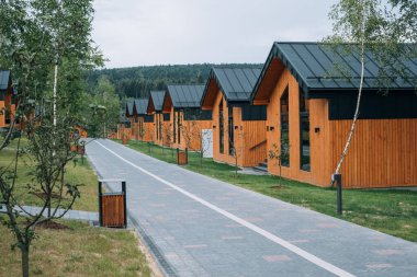 Gezgin kadın otelin yanındaki ızgarada yemek pişiriyor. Barbekü yapan kadın