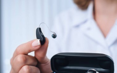 Hastanın işitme cihazını dahili güç bankası olan özel taşınabilir Smart Charger ile şarj etmesi. Erkeklerin elindeki dava işitme cihazlarını kuru ve güvenli tutuyor.