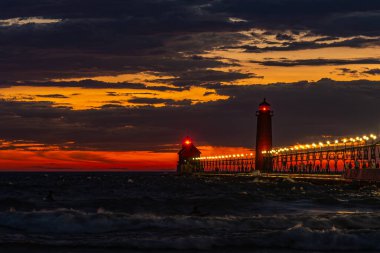 Gün batımında fırtına bulutları Grand Haven, Michigan deniz fenerinde renkli ve çarpıcı bir ışık yaratıyor. Yüksek kalite fotoğraf
