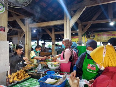 İnsanların Ngasem 'deki geleneksel Yogyakarta pazarında kahvaltı edişinin bulanık, bulanık ve gürültülü görüntüleri.