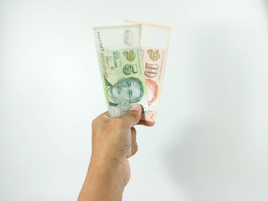 El ele tutuşarak 5 ve 10 Singapur Doları banknotları alışverişe hazır. Singapur para birimi alışverişte çok değerlidir..