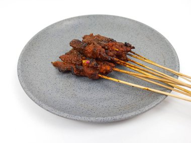 Satay ya da Sate gri tabakta, ünlü bir Endonezya geleneksel yemeği. Genellikle tavuk eti, sığır eti ya da kuzudan yapılır ve fıstık sosuyla servis edilir..