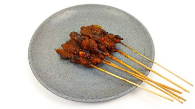 Satay ya da Sate gri tabakta, ünlü bir Endonezya geleneksel yemeği. Genellikle tavuk eti, sığır eti ya da kuzudan yapılır ve fıstık sosuyla servis edilir..