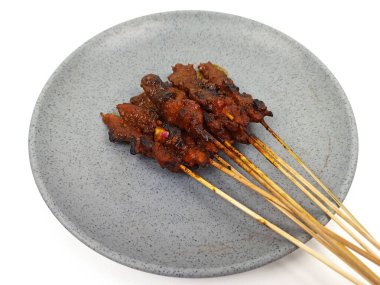 Satay ya da Sate gri tabakta, ünlü bir Endonezya geleneksel yemeği. Genellikle tavuk eti, sığır eti ya da kuzudan yapılır ve fıstık sosuyla servis edilir..