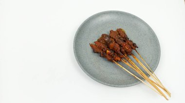 Satay ya da Sate gri tabakta, ünlü bir Endonezya geleneksel yemeği. Genellikle tavuk eti, sığır eti ya da kuzudan yapılır ve fıstık sosuyla servis edilir..