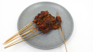 Satay ya da Sate gri tabakta, ünlü bir Endonezya geleneksel yemeği. Genellikle tavuk eti, sığır eti ya da kuzudan yapılır ve fıstık sosuyla servis edilir..