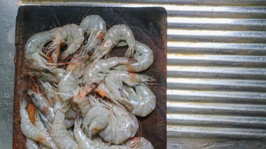 Kesme tahtasından taze karides temizlendi. Çiğ karides sağlıklı deniz ürünüdür.