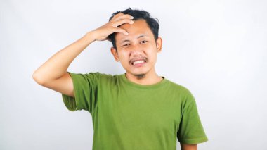 Bir adamın başı dönüyor ve başını beyaz bir arka planda tutuyor.