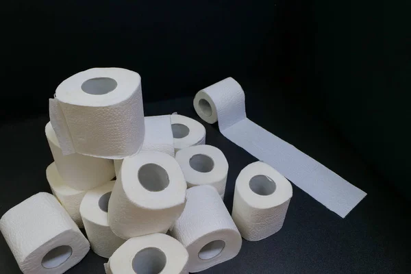 Siyah arka planda tuvalet kağıdı ruloları