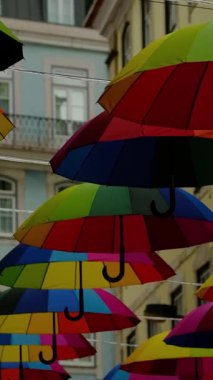 Sokakta asılı çok renkli şemsiyeler.