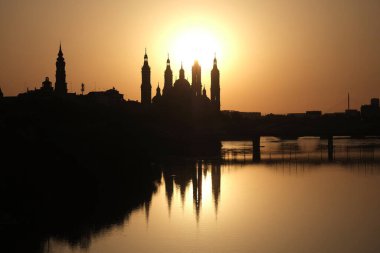 Suda gün batımının yansıması olan katedral silueti. İspanya. El Pilar, Zaragoza