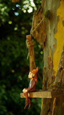 Küçük bir çocuk bahçede oturur ve oyuncağa bakar.